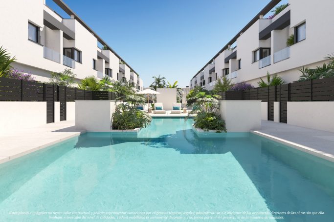 Vista de una piscina rodeada de edificios modernos y vegetación.